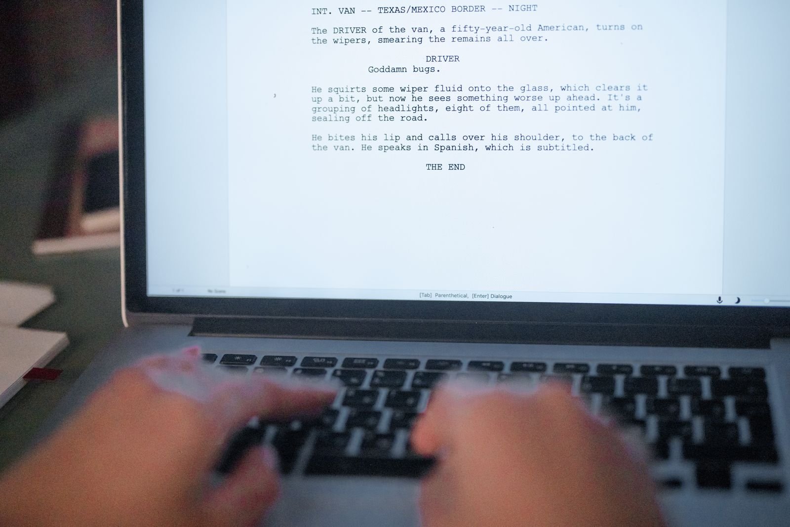 Mains sur un clavier devant un texte affiche a l ecran